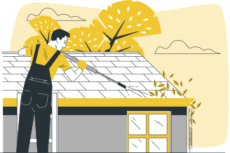 A person in overalls and gloves pressure washing a house roof and clearing leaves from a gutter.